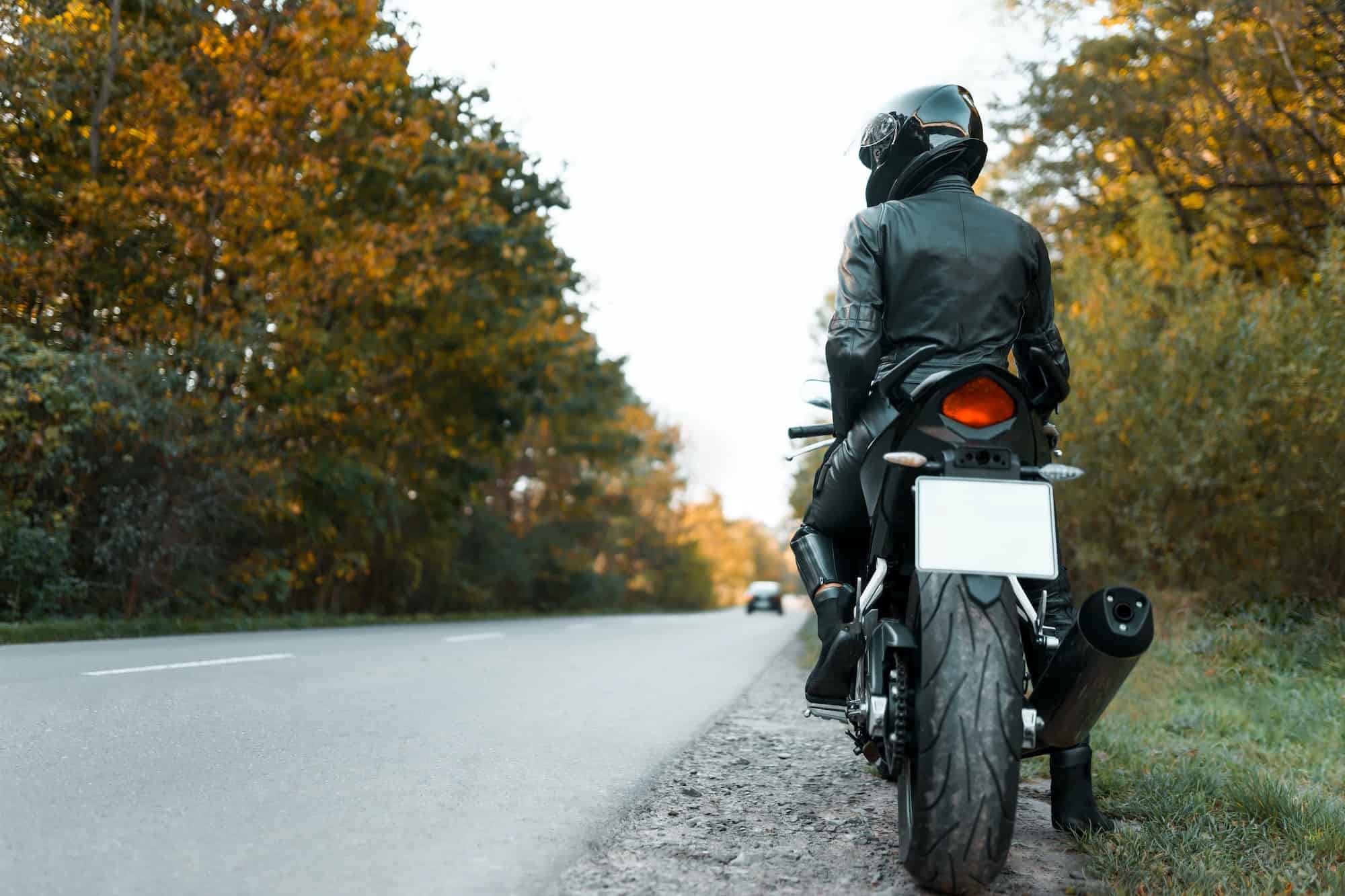 Motorcyclist in leather outfit on the roadside